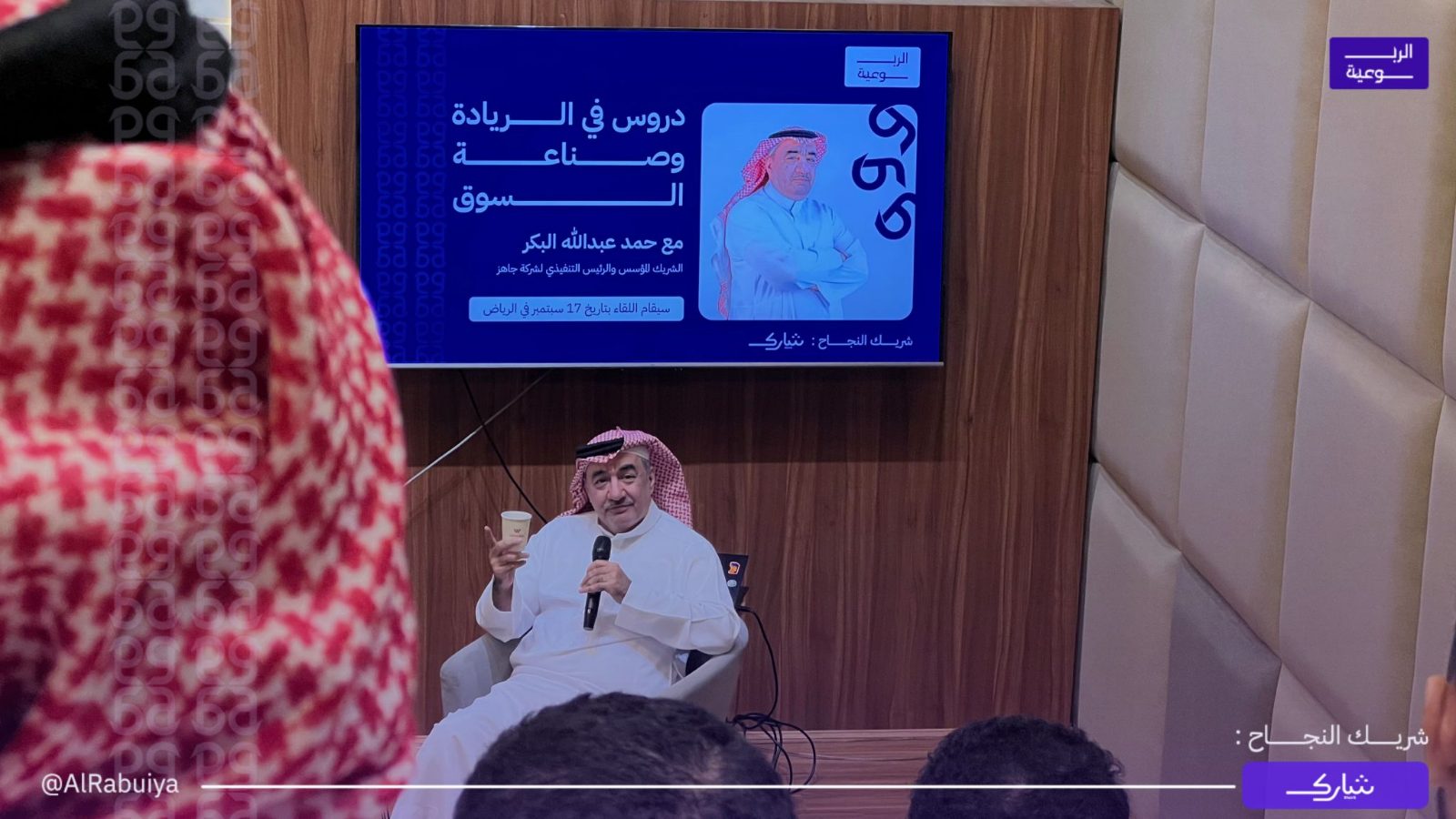 حمد البكر يتحدث بالمايكروفون خلال لقاء الربوعية